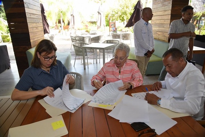 Puerto Plata, R.D. – Con el objetivo de prevenir que más de 100 toneladas de residuos plásticos lleguen al océano para el año 2027, fue lanzado este miércoles 11 de junio el Programa Comunidades Circulares, una iniciativa liderada por la Fundación Genera del Grupo ITM, con el respaldo de Port Taíno Bay, la Alcaldía de Puerto Plata, el Clúster Turístico del Destino Puerto Plata, y múltiples organizaciones comunitarias e institucionales. El acto de lanzamiento tuvo lugar en la Cantina Latina de Port Taíno Bay, y reunió a autoridades locales, representantes del sector privado y comunitario, así como actores clave del ecosistema turístico y ambiental de la provincia. Durante el evento se formalizó la integración del Clúster Turístico del Destino Puerto Plata al programa, mediante la firma de un acuerdo de colaboración suscrito por varias entidades participantes, y firmado por Birgitt Heinsen en representación del Clúster. El programa, desarrollado bajo el lema “De las cañadas al mar, Puerto Plata hay que limpiar”, promueve un modelo de gestión integral de residuos sólidos que incluye acciones de gobernanza ambiental, educación, participación comunitaria y sostenibilidad empresarial. Entre sus principales objetivos se destacan: promover la gestión eficiente y responsable de los residuos sólidos urbanos en el municipio de Puerto Plata; desarrollar campañas de sensibilización ambiental mediante medios, redes sociales y actividades comunitarias; e implementar un programa piloto de reciclaje y manejo de residuos en las comunidades de Ensanche Dubocq, Playa Oeste y Vía Férrea, con énfasis en la reducción de plásticos de un solo uso. “Esta iniciativa es un ejemplo del compromiso social y medioambiental que tenemos las empresas del sector turismo. Celebramos este tipo de alianzas que demuestran que sí podemos trabajar unidos por nuestras comunidades”, expresó Birgitt Heinsen, presidente del Clúster. Añadió, “La Fundación Genera ITM cuenta con el respaldo de la cadena de valor, y estamos seguros de que este proyecto servirá de inspiración para otras comunidades en la zona. Es una muestra concreta de que en Puerto Plata el turismo avanza hacia un modelo más sostenible”. Como parte de su compromiso, el Clúster participará activamente en las campañas de sensibilización y promoverá la adopción del programa de reciclaje entre sus afiliados del sector turístico, contribuyendo así al posicionamiento de Puerto Plata como un destino alineado con la sostenibilidad y la responsabilidad ambiental.
